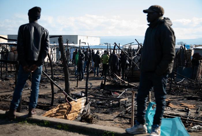 Immigrati tra le baracche distrutte a San Ferdinando