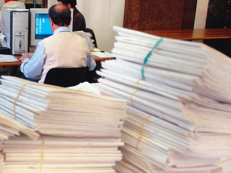 Un impiegato sommerso da documenti
