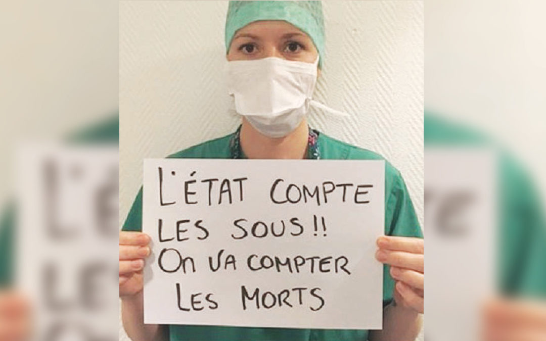 Una dottoressa francese mostra il cartello “Lo Stato conta i soldi, noi conteremo i morti”