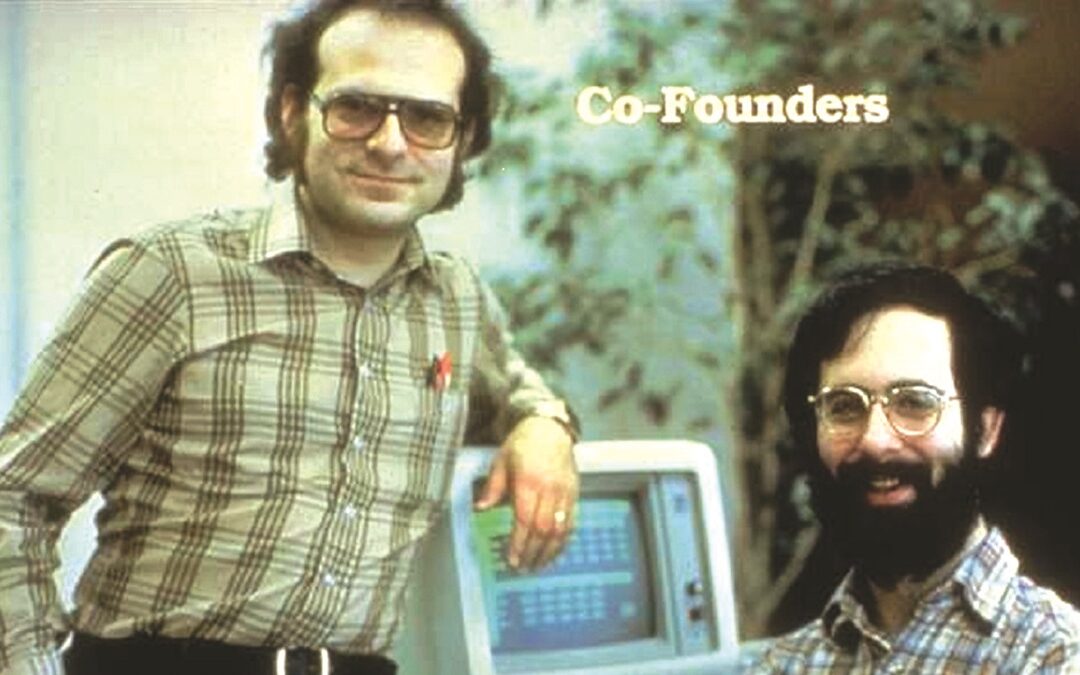 L’inventore di VisiCalc, ovvero il primo Foglio di Calcolo, Dan Bricklin (a destra nella foto) insieme   al suo amico e socio, Bob Frankston;   (sotto) una schermata di VisiCalc in esecuzione su un Apple II e (a lato in alto) la targa commemorativa appesa nell’aula della prestigiosa università di Harvard nel 1999, per il ventesimo anniversario dell’uscita di VisiCalc