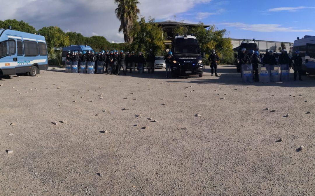 Forze dell'ordine schierate e i sassi lanciati dalla tendopoli