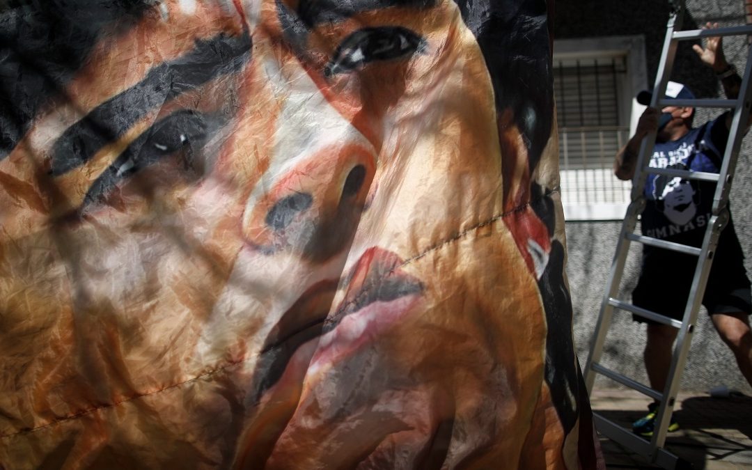Tifosi appendono uno striscione dedicato Maradona all'esterno della clinica di La Plata