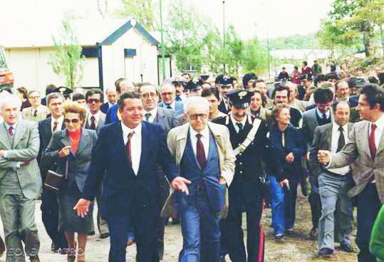 Giuseppe Zamberletti (al centro, con l'abito blu e l'impermeabile) durante una visita in Basilicata da Commissario all'emergenza post-terremoto 1980