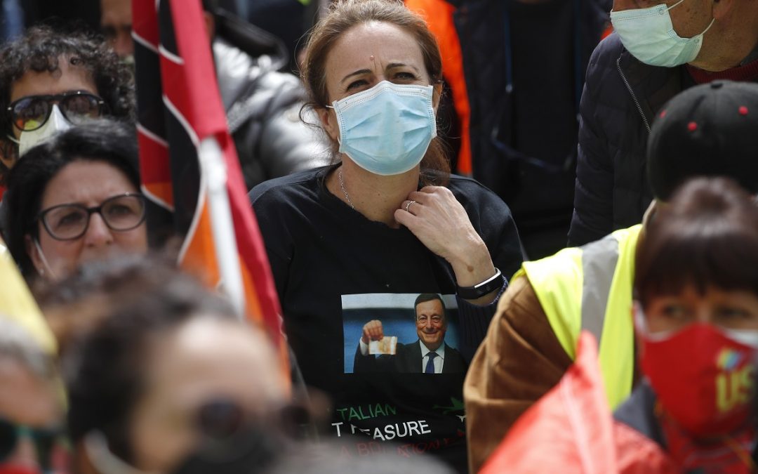Una manifestazione davanti al Ministero per lo Sviluppo economico: una donna con la maglietta di Mario Draghi