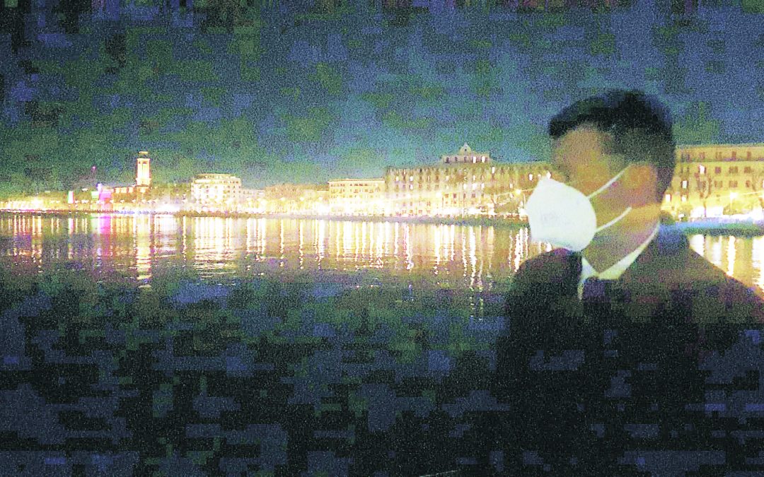 Il sindaco Decaro osserva sotto un lampione spento la città da lontano