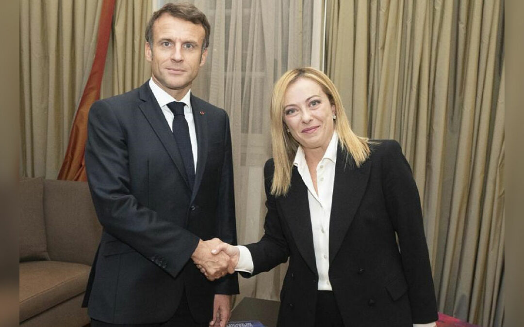 Una stretta di mano tra Emmanuel Macron e Giorgia Meloni