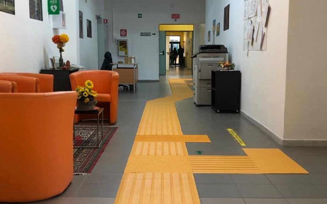 Il corridoio di una scuola dov'è presente il percorso dedicato ai non vedenti