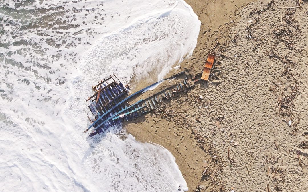 Il barcone distrutto arenato sulla spiaggia di Cutro