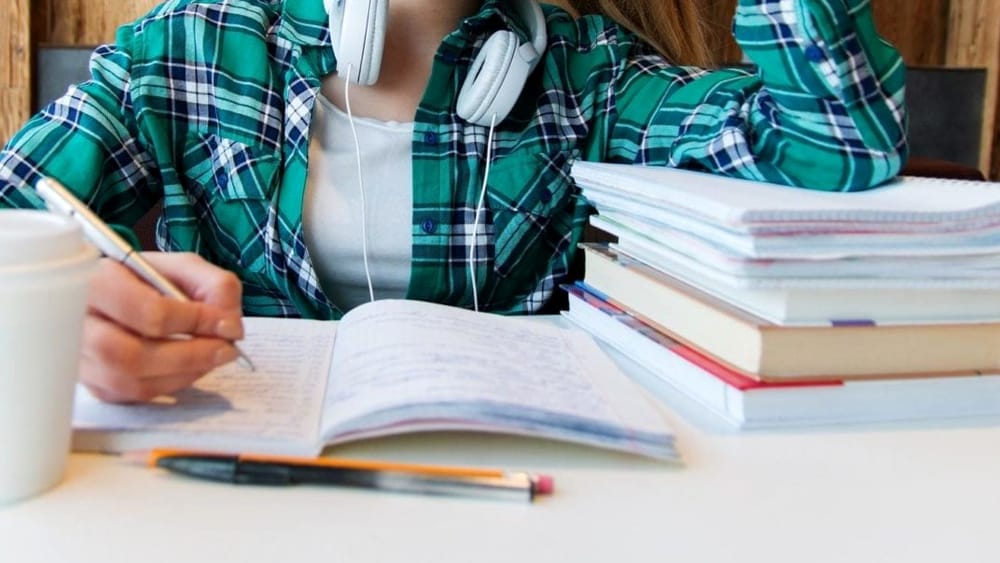 Uno studente sui libri con le cuffie