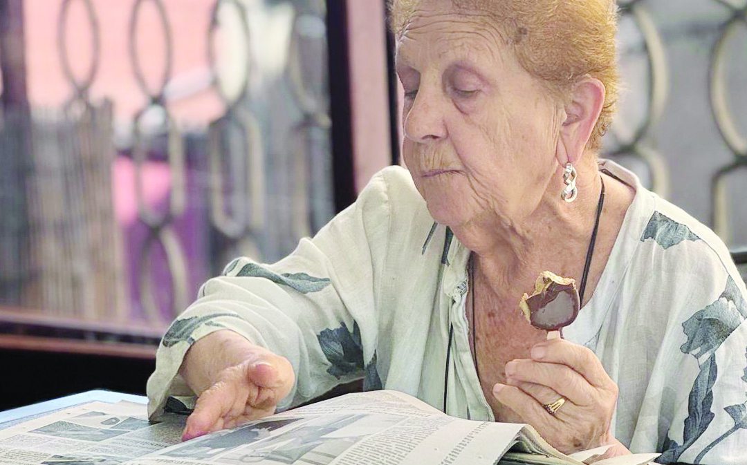 Una signora legge il nostro giornale mentre gusta un gelato in un bar di Feroleto Antico