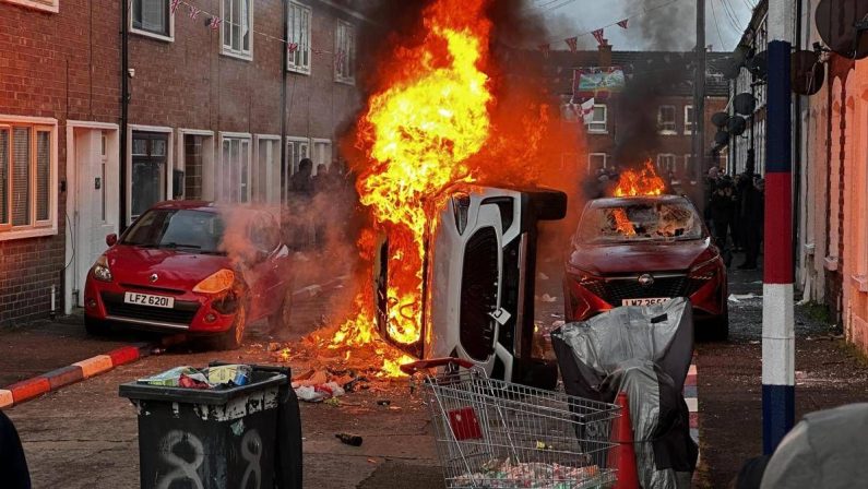 Belfast, proteste e violenze anti-migranti dopo aggressione choc: è ‘caccia’ agli stranieri. Elon Musk e Reform Uk cavalcano i ‘riot’