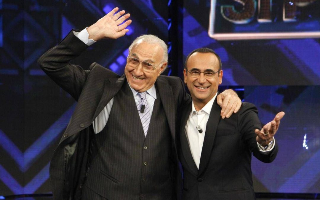 Baudo, Conti ricorda il grande conduttore: “Lui è la tv, indimenticabili i suoi abbracci paterni”