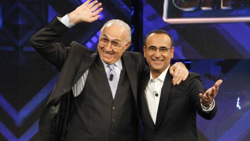 Baudo, Conti ricorda il grande conduttore: “Lui è la tv, indimenticabili i suoi abbracci paterni”